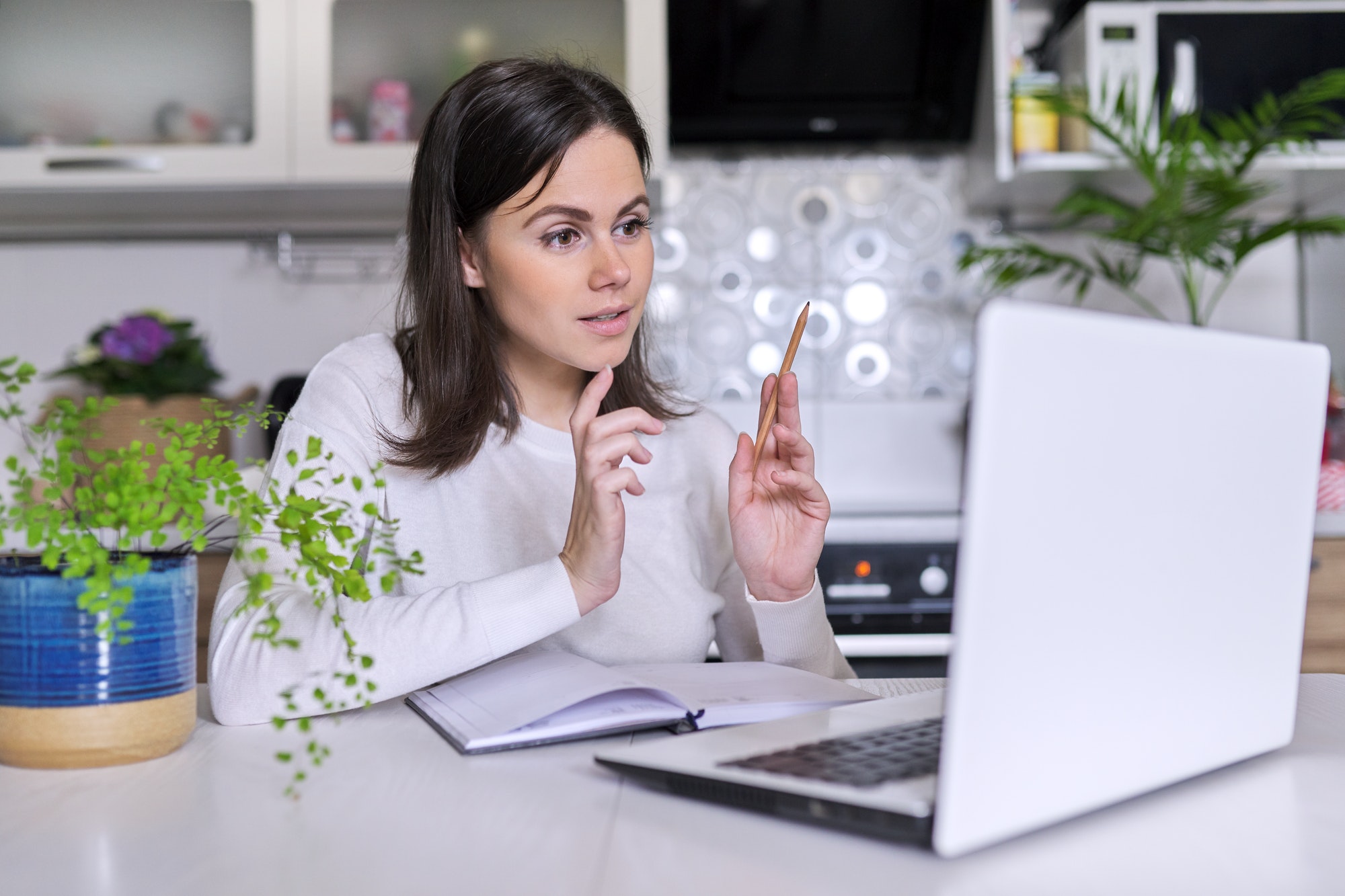 Young female working in home office using laptop, business woman, teacher